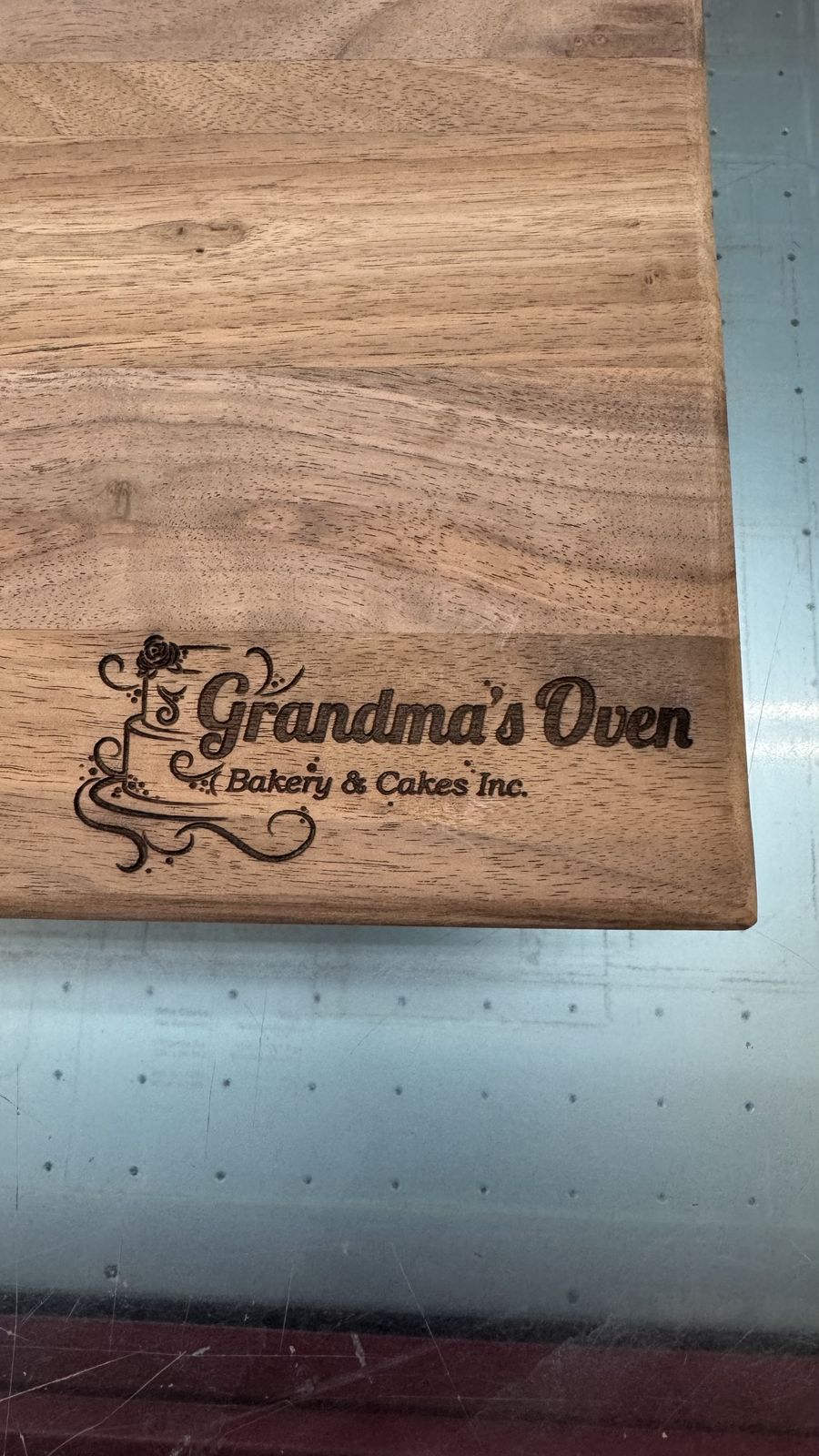 Business logo engraved on the corner of a walnut serving board